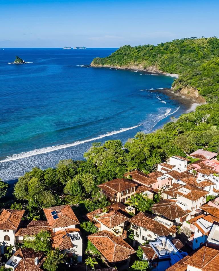 Aerial view of the coastline and red-tiled rooftops at Las Catalinas